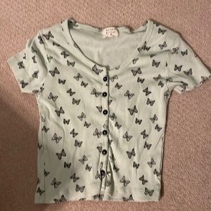 Mint/ light green shirt. It has black butterfly’s on it and is a V neck cut.